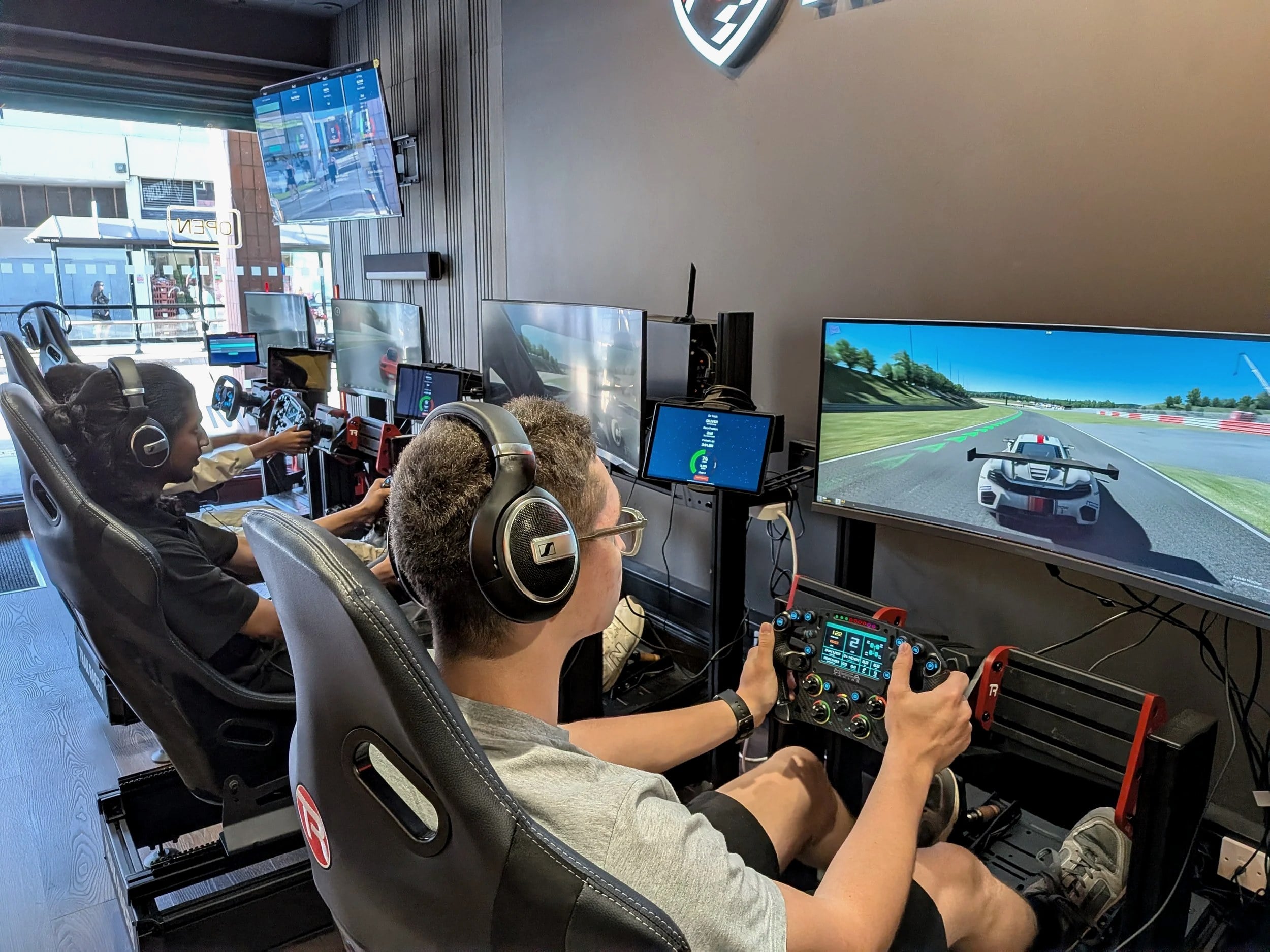 Drivers on Racecraft Sim direct-drive rigs during a session